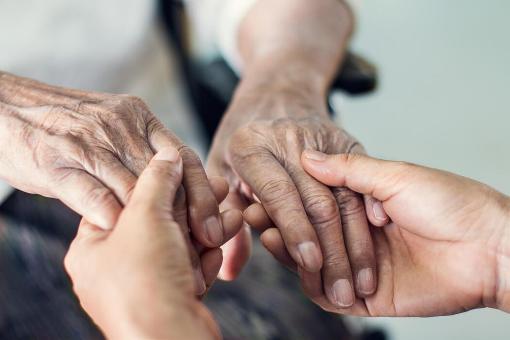 A caregiver holding hands with a senior